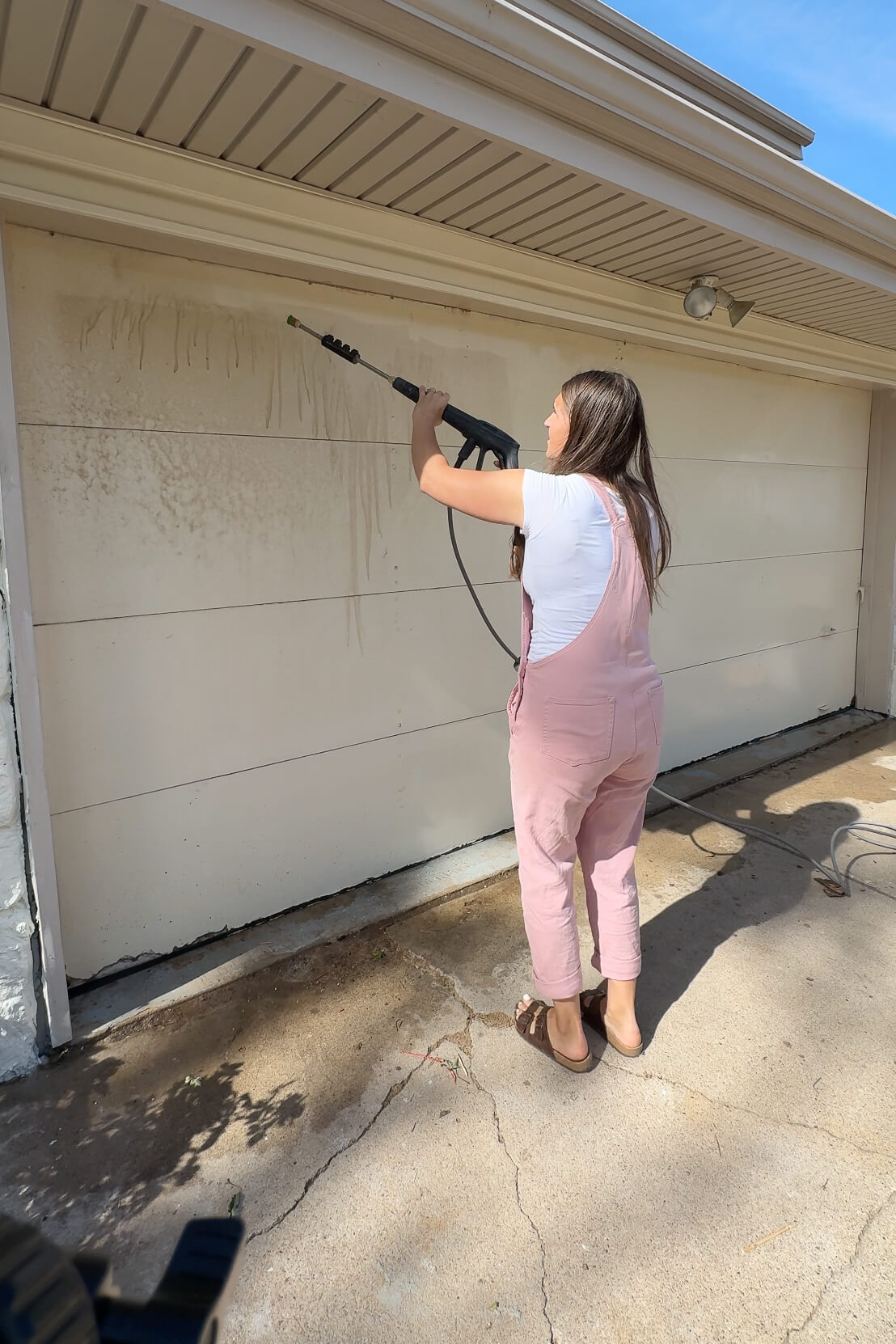 Using a pressure washer to clean my garage door.